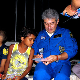 Astronauta brasileiro Marcos Pontes dando autógrafo a um menino