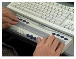 Pessoa utilizando uma linha braille em frente a um teclado