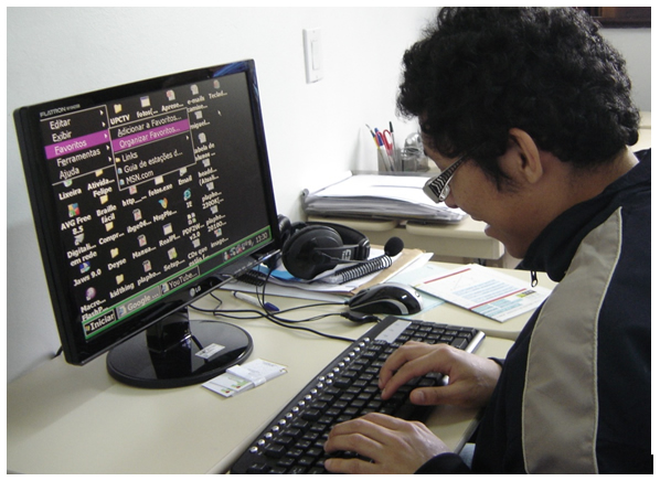 Pessoa com baixa visão utilizando um computador com a fonte aumentada e com alto contraste